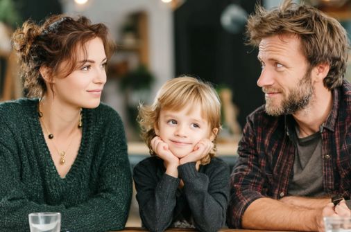 Guardian ad Litem Attorney Riverview FL representing a family, showing parents and a child sitting together and smiling in a warm, relaxed setting.